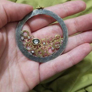 Large circular pendant with 925 sterling silver, 24 karat gold, and dimonds